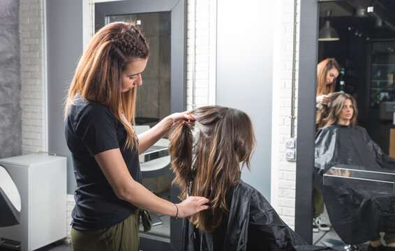 Profesional de peluquer&iacute;a trabajando, peinando, ti&ntilde;endo y cortando cabello.
