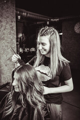 Profesional de peluquería trabajando, peinando, tiñendo y cortando cabello.