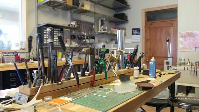 Panning Shot Of Jewelry Workshop Area. Round, chain, flat nose pliers and other jeweler instruments.