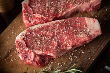 seasoned raw sirloin beef steak on cutting board