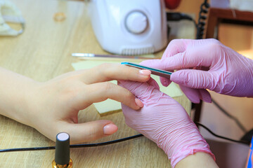 Hands of client and master during manicure process