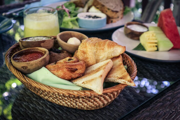 bread basket with butter, jam and fresh fruits