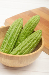 sliced bitter melon, Peria, Pare, vegetables in wooden bowl