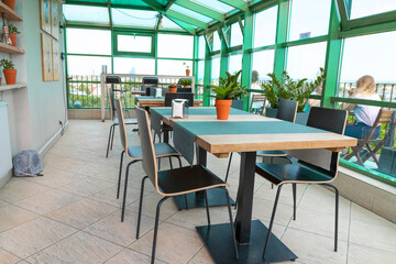 A cozy wicker table in the outdoor cafe-bar on the rooftop in the morning with view on a city