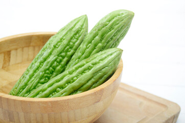 sliced bitter melon, Peria, Pare, vegetables in wooden bowl