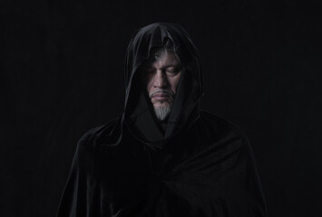 Fototapeta na wymiar portrait of a medieval monk with a hood on a black background