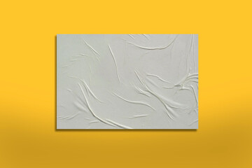 White crumpled sheet of paper on a yellow background.