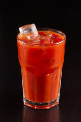 Cocktail Bloody Mary with ice in glass on a wooden table