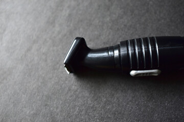 Naklejka premium Black ear and nose trimmer on a black background