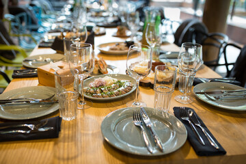 festive served table, plates, glasses, forks, knives, restaurant table