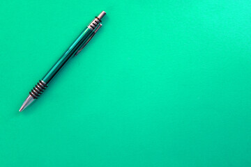 Green pen on a green background. Copy space.