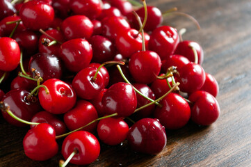 Fresh garden cherries on wooden table. Summer harvest. Delicious red berries.