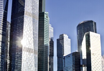 Office and residential skyscrapers on bright sun and clear blue sky background. Commercial real estate. Modern business city district. Office buildings exterior. Financial city district. Downtown.