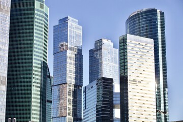 Office and residential skyscrapers on bright sun and clear blue sky background. Commercial real estate. Modern business city district. Office buildings exterior. Financial city district. Downtown.