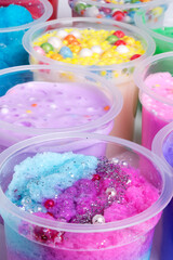 Various bows of colored slime with colorful dots over light gray background.