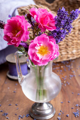 Small vintage glass vase with wild pink roses and purple lavender