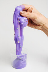 Boxes of colored slime with decorations over light background. Children fun and leisure activities. 