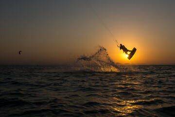 kiter does a difficult trick on a background of incredible sunset
