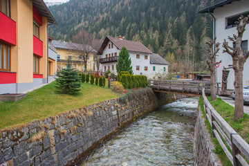 Fototapeta na wymiar Farmhouses with Fence and Mountains in the Background in April, Mallnitz, High Tauern, Alps, Austria, Europe