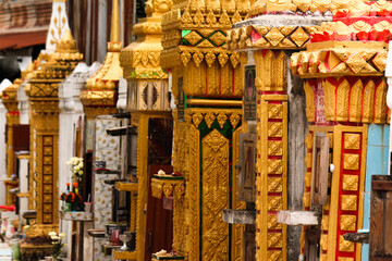 Collection of stupas and pagodas used as graves aligned along temple walls of a wat in Siamese Lao PDR, Southeast Asia