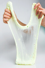 Boxes of colored slime with decorations over light background. Children fun and leisure activities. 