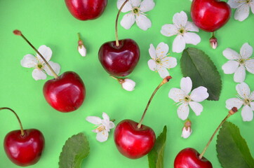 Colourful bright pattern with ripe cherry, flowers and leaf. Top view. fresh organic berries macro fruit background