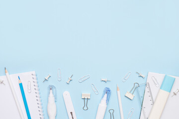 School supplies of blue and white colors on a blue background. copy space. Flat lay