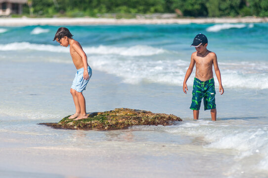 Dos ni&ntilde;os exploran en la playa durante vacaciones de verano en el Caribe