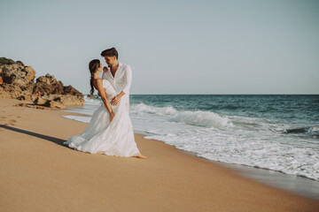 Fototapeta na wymiar Wedding beach young couple sunset sand white happy sea waves