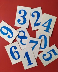 Large blue paper numbers on a red background