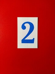Large blue paper numbers on a red background