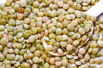 Heap of green lentil texture as background. Uncooked lentils. Top view