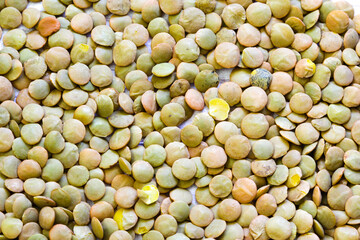 Heap of green lentil texture as background. Uncooked lentils. Top view