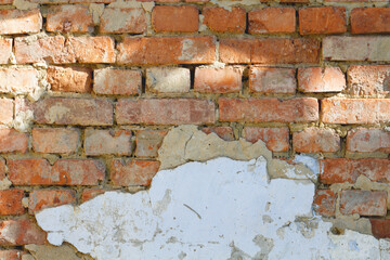 old brick wall with peeling plaster
