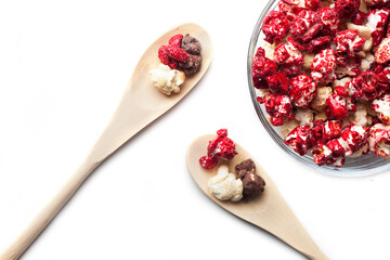 Rustic colored cups of Chocolate, Strawberry and Cream Gourmet Popcorn over white background.