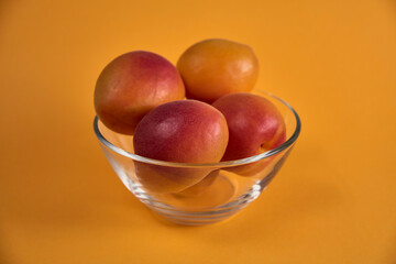 Fresh juicy apricots in a transparent glass plate. Macro.