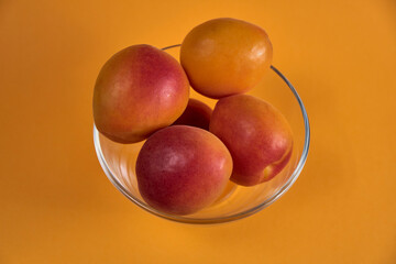 Fresh juicy apricots in a transparent glass plate. Macro.