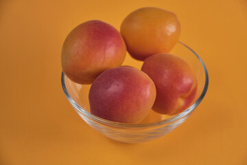 Fresh juicy apricots in a transparent glass plate. Macro.