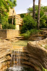 Small waterfall. Maya stylized garden. Green patio with clear pools. 