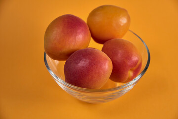 Fresh juicy apricots in a transparent glass plate. Macro.