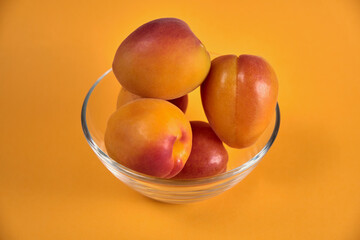 Fresh juicy apricots in a transparent glass plate. Macro.