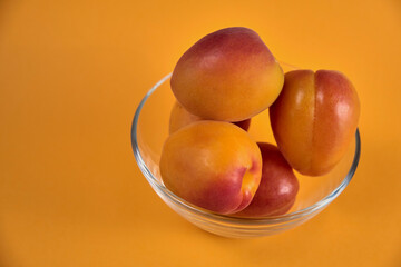 Fresh juicy apricots in a transparent glass plate. Macro.