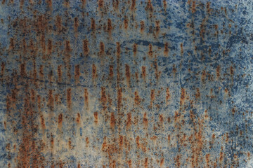 Background texture of concrete with corrosion and rusty metal. Sunlight falls to the surface and leaves a beautiful pattern. Doors and wall of an industrial building.