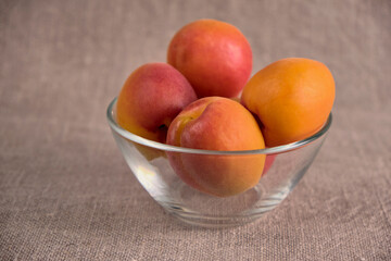 Fresh juicy apricots in a transparent glass plate. Macro.