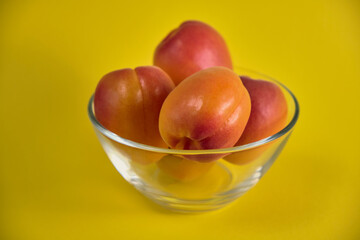 Fresh juicy apricots in a transparent glass plate. Macro.