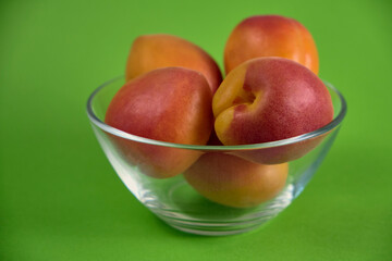 Fresh juicy apricots in a transparent glass plate. Macro.