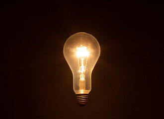 glowing light bulb against dark background