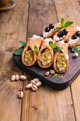 Cannoli Sicily. Traditional Italian sweet with ricotta and various fillings. Food on a wooden cutting board.