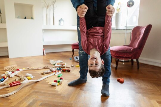 Low section of father lifting son in living room