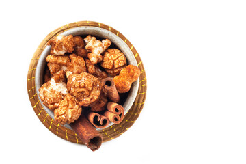 Rustic cup of gourmet cinnamon popcorn on white background.